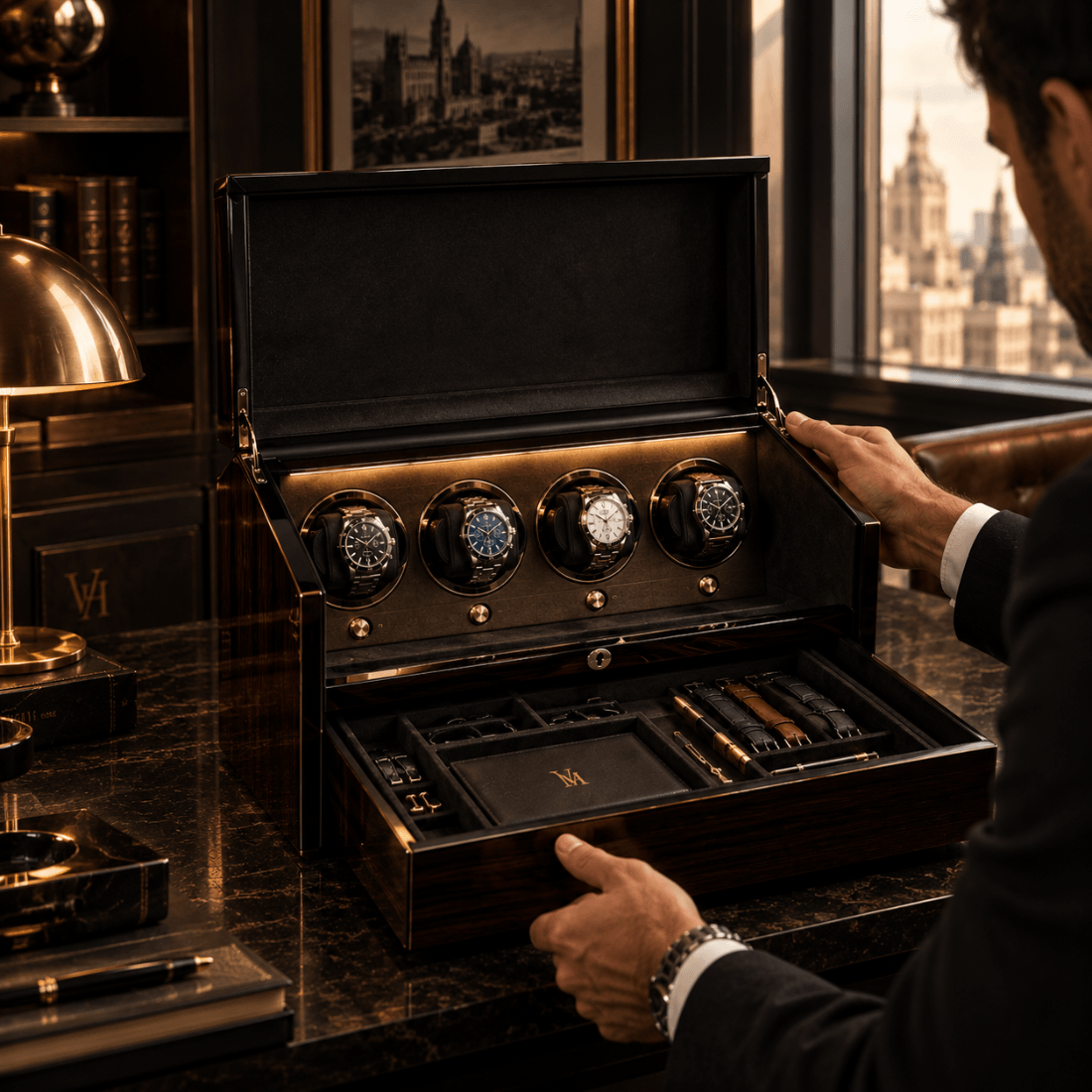 A luxury wooden watch winder and storage box, opened to reveal four rotating watch holders with watches inside and an open lower drawer with compartments and accessories. A person in a dark suit is shown from the side, reaching toward the box, set against a dark, elegant room with a window view.